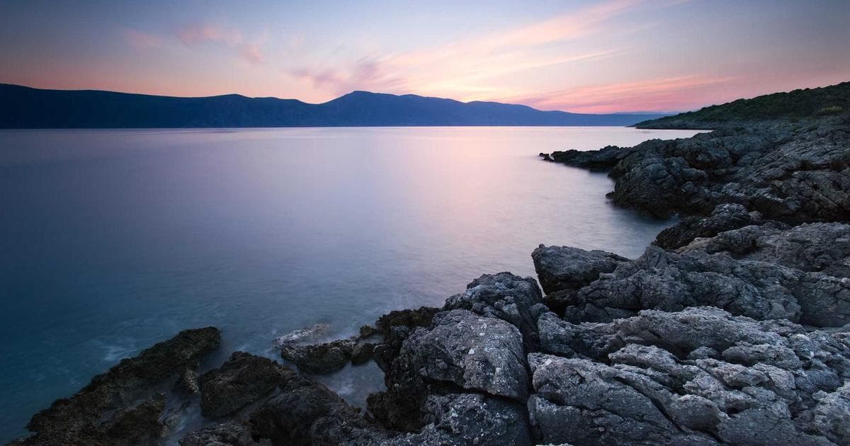 Aerial view of a small Arctic community in Nunavut surrounded by tundra and water