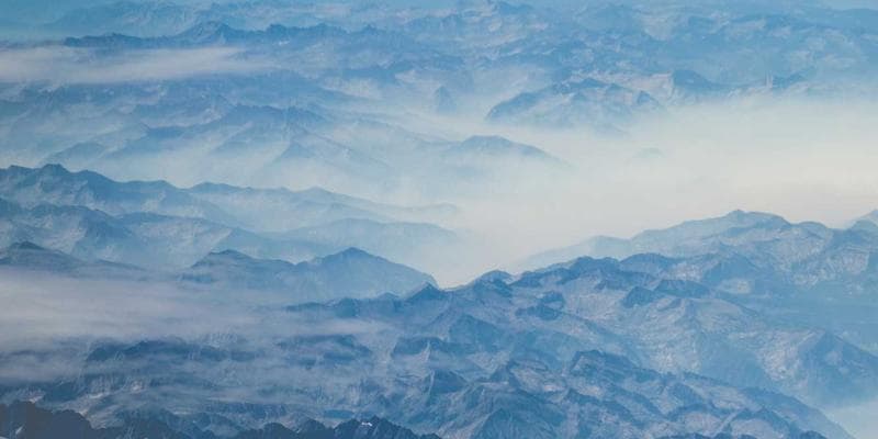 Diverse group of tech workers coding on laptops in a modern open-plan office