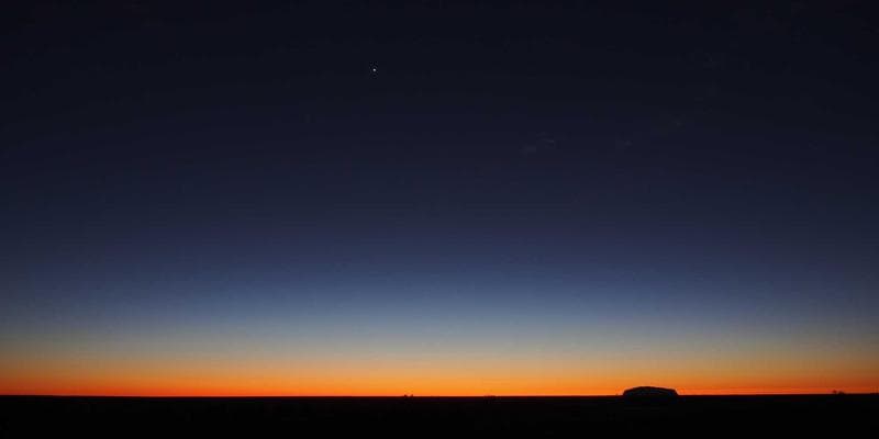 Newcomer family reading documents and filling out forms at a kitchen table, symbolizing the application process.