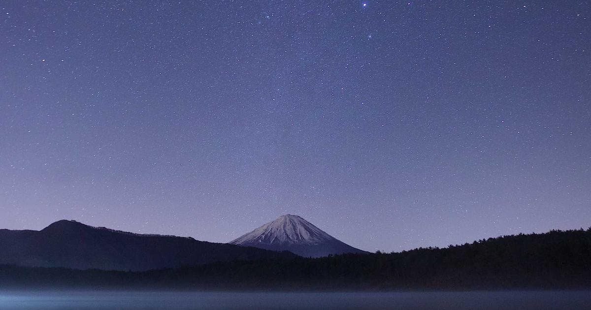 Person proudly holding a Canadian citizenship certificate and passport, with a Canadian flag.