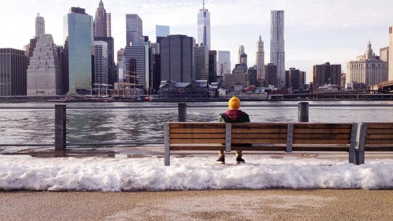 Person writing a resume on a laptop representing job application preparation for newcomers in Canada