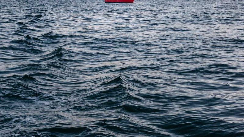 Camping tent set up near a lake surrounded by Canadian mountains and forests