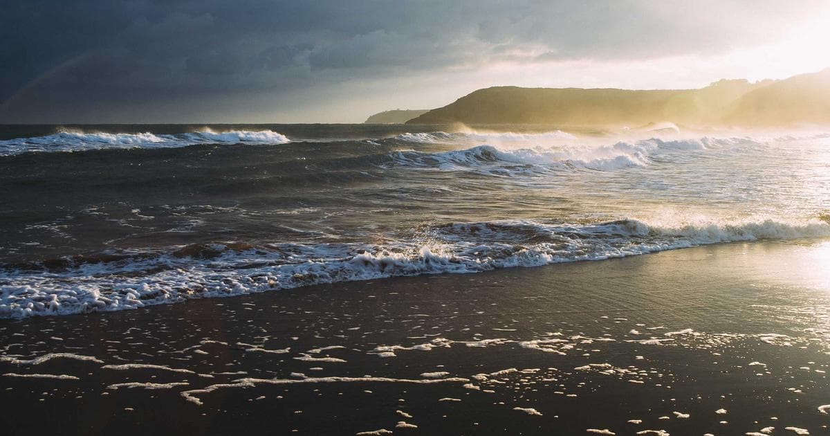 Hard hat and safety vest on a desk with WorkSafeBC documents, illustrating a claim filing guide.