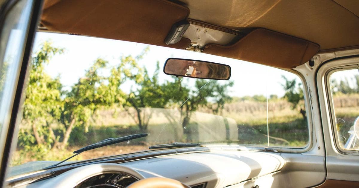 Hand holding a house key with a BC flag or a house in the background, representing the homeowner grant application.