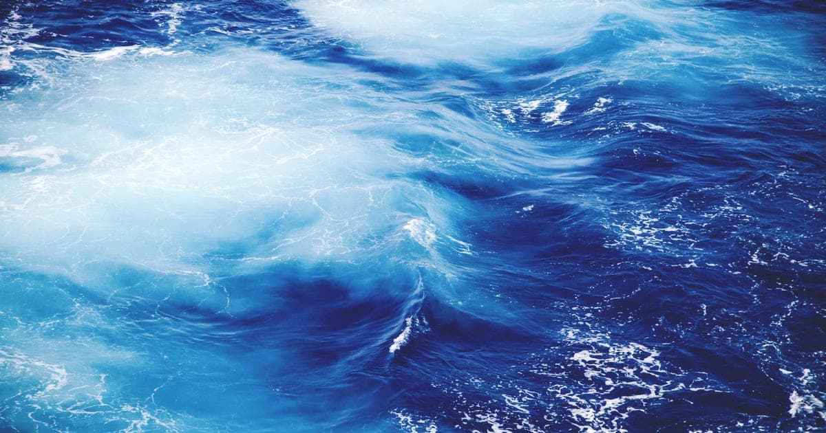 Person holding a Canadian bank card in front of a bank branch