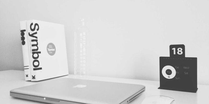 Organized newcomer document folders on a desk beside a laptop