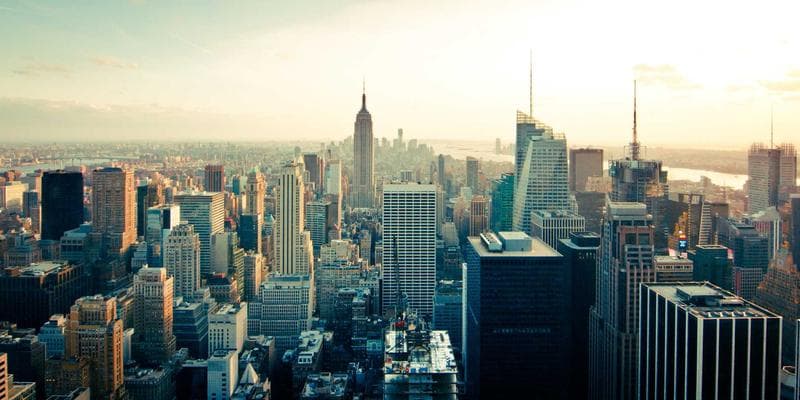 Real estate agent handing keys to a happy couple in front of a Canadian house